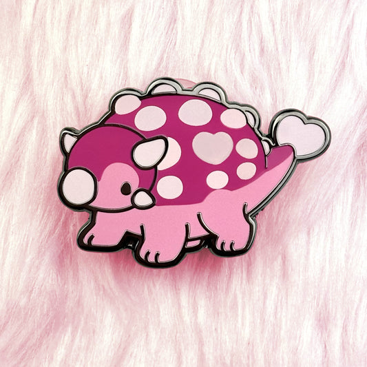 Cute dinosaur enamel pin. Ankylosaurus pin of a pink dino with a loveheart spot. black nickel plating