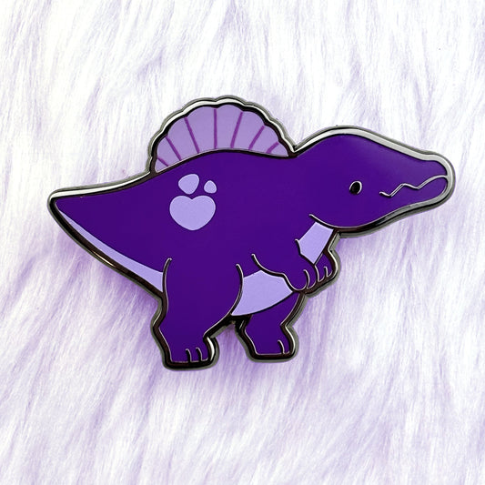 A cute dinosaur enamel pin of a purple spinosaurus with black nickel plating.